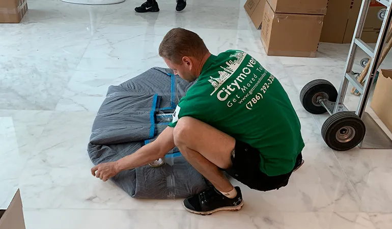 City Movers crew member wrapping furniture in a moving blanket