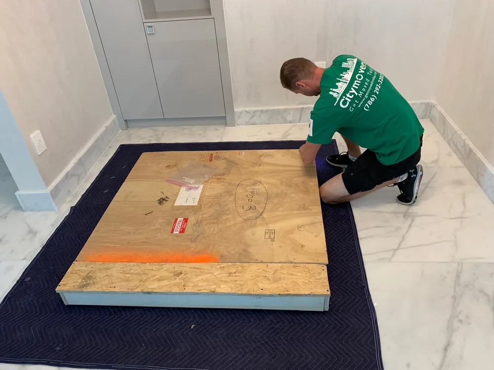 Mover securing a custom crate around large furniture