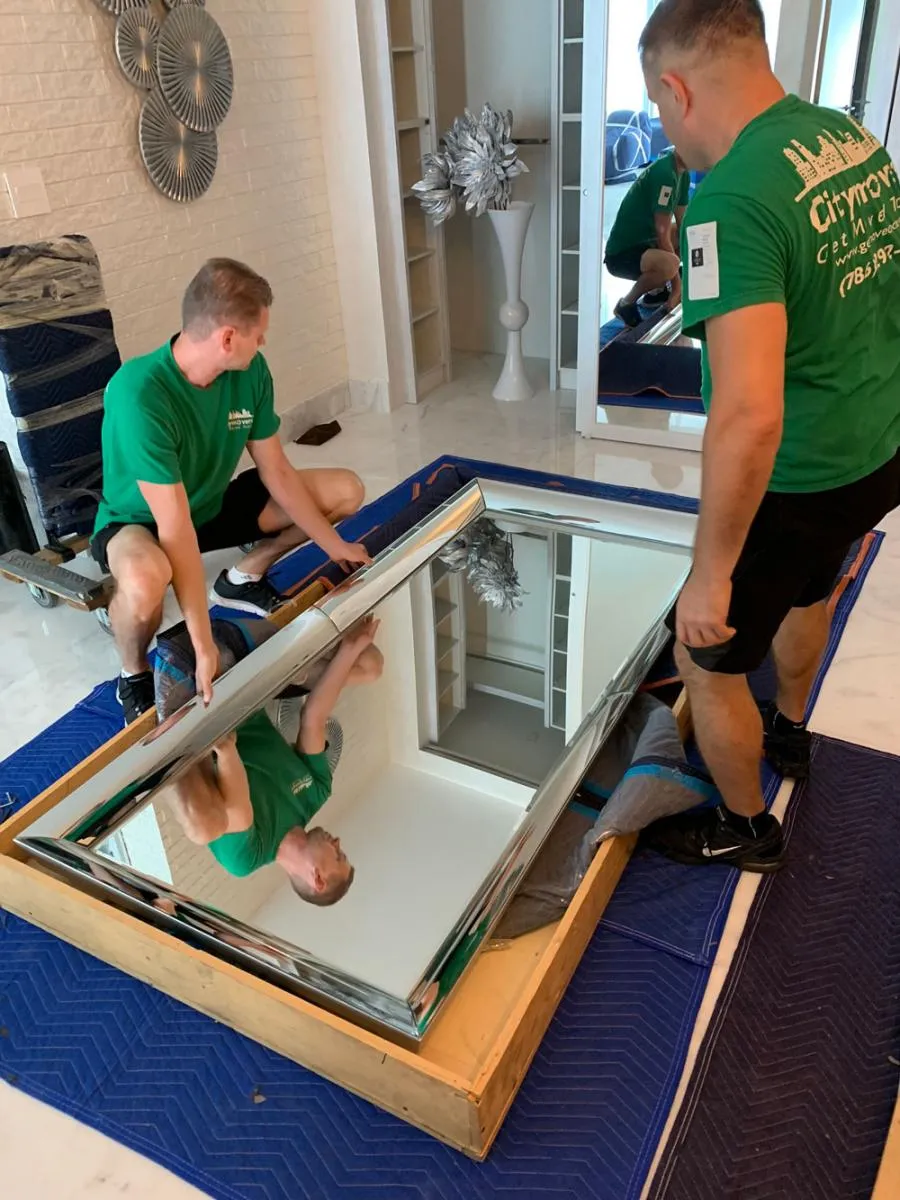 Two City Movers crew members crating a large mirror