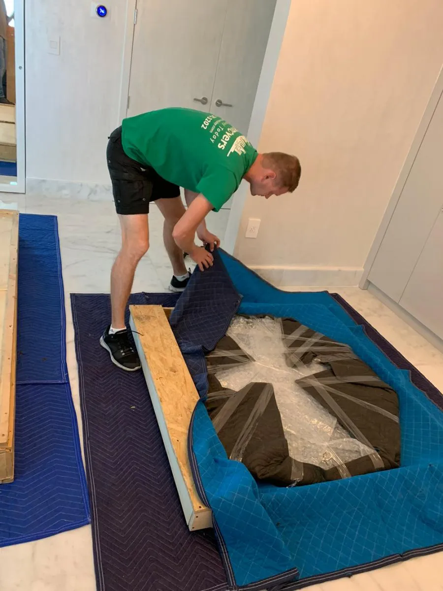 Mover wrapping a table in padding and plastic