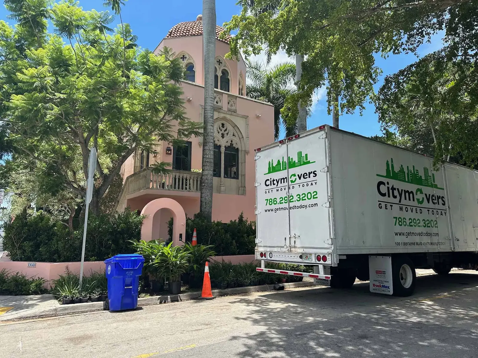City Movers truck parked at a pink Mediterranean-style home
